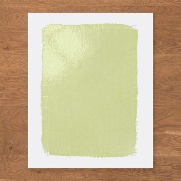 A freshly coated sheet, pale yellow-green with brush marks, on an oak bench